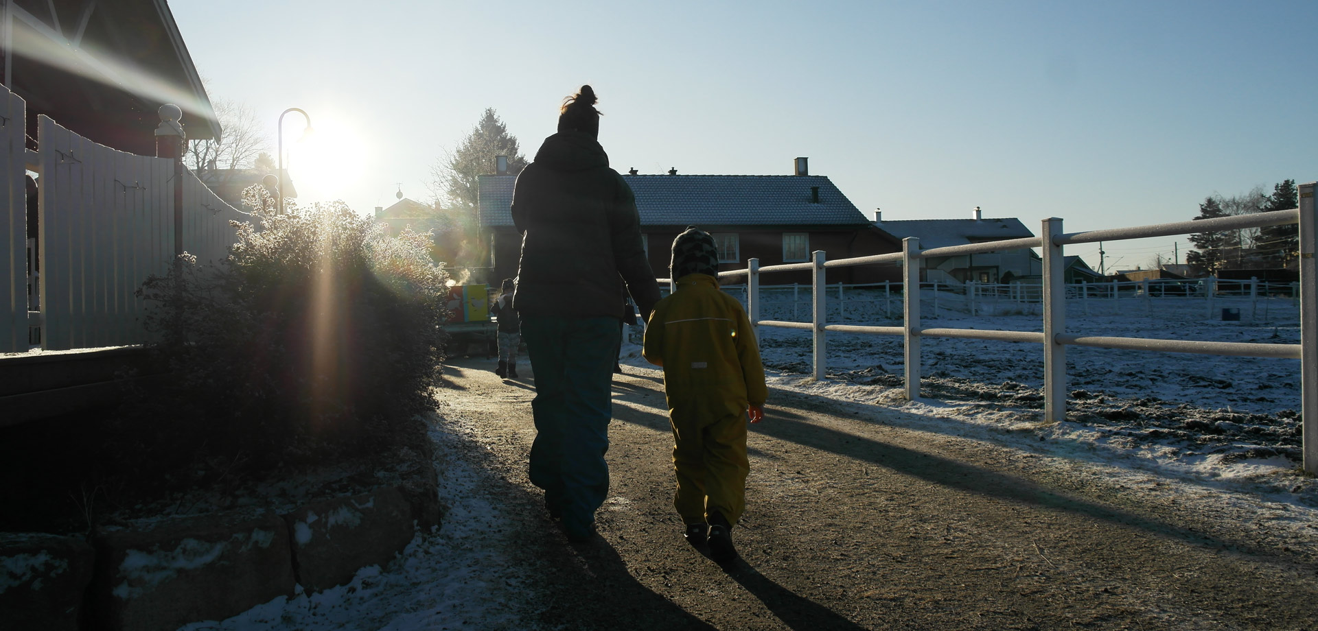 Et barn og en voksen går sammen på Hjørgunn i vinterlys