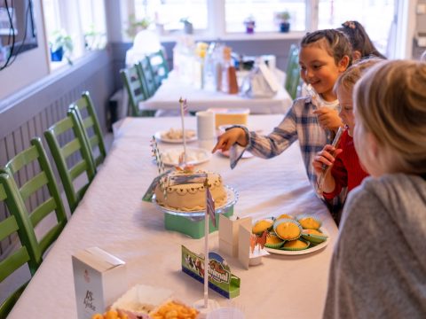 Barn samlet rundt et pyntet bursdagsbord på Hjørgunn