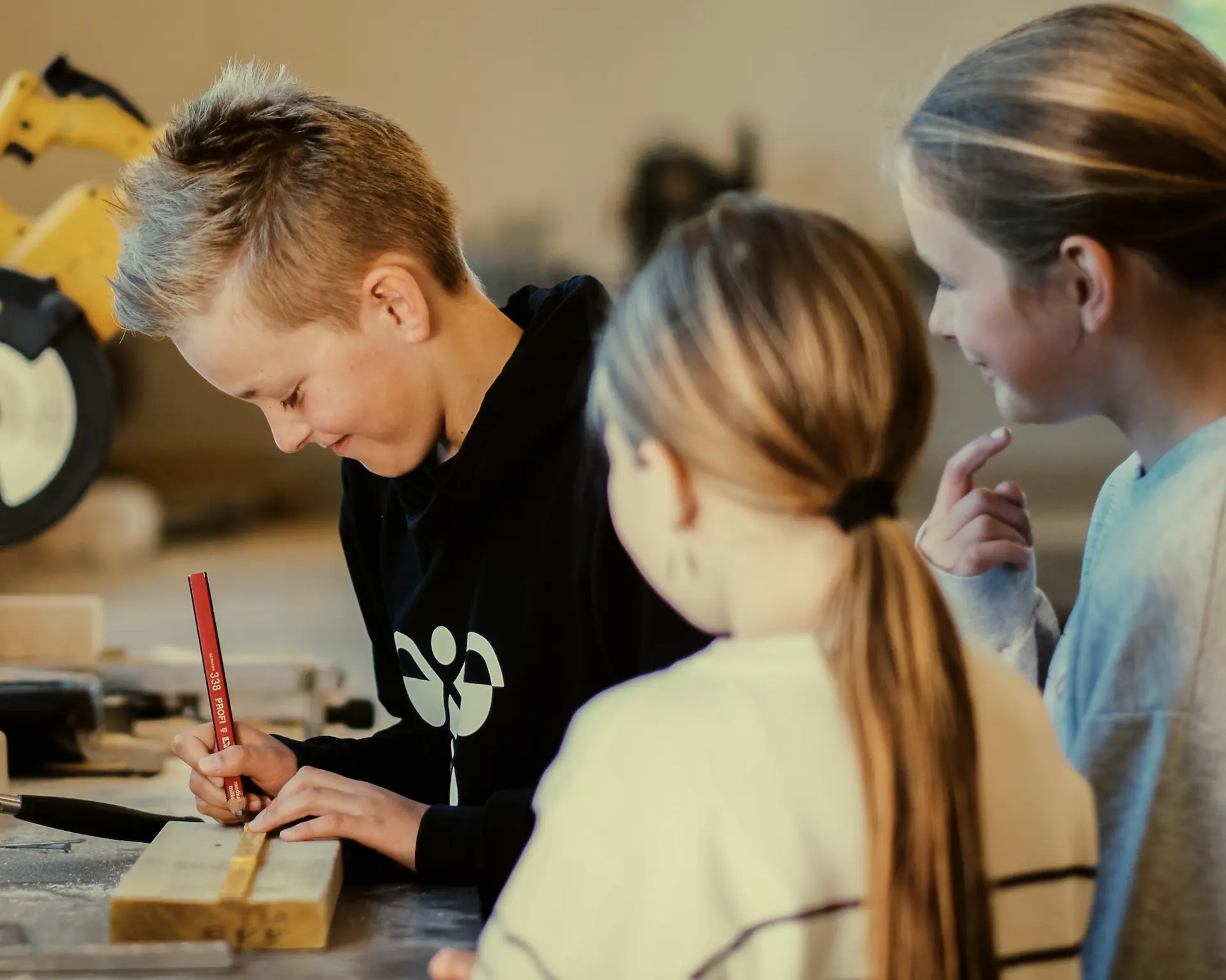 Barn som jobber med treprosjekt i verkstedet